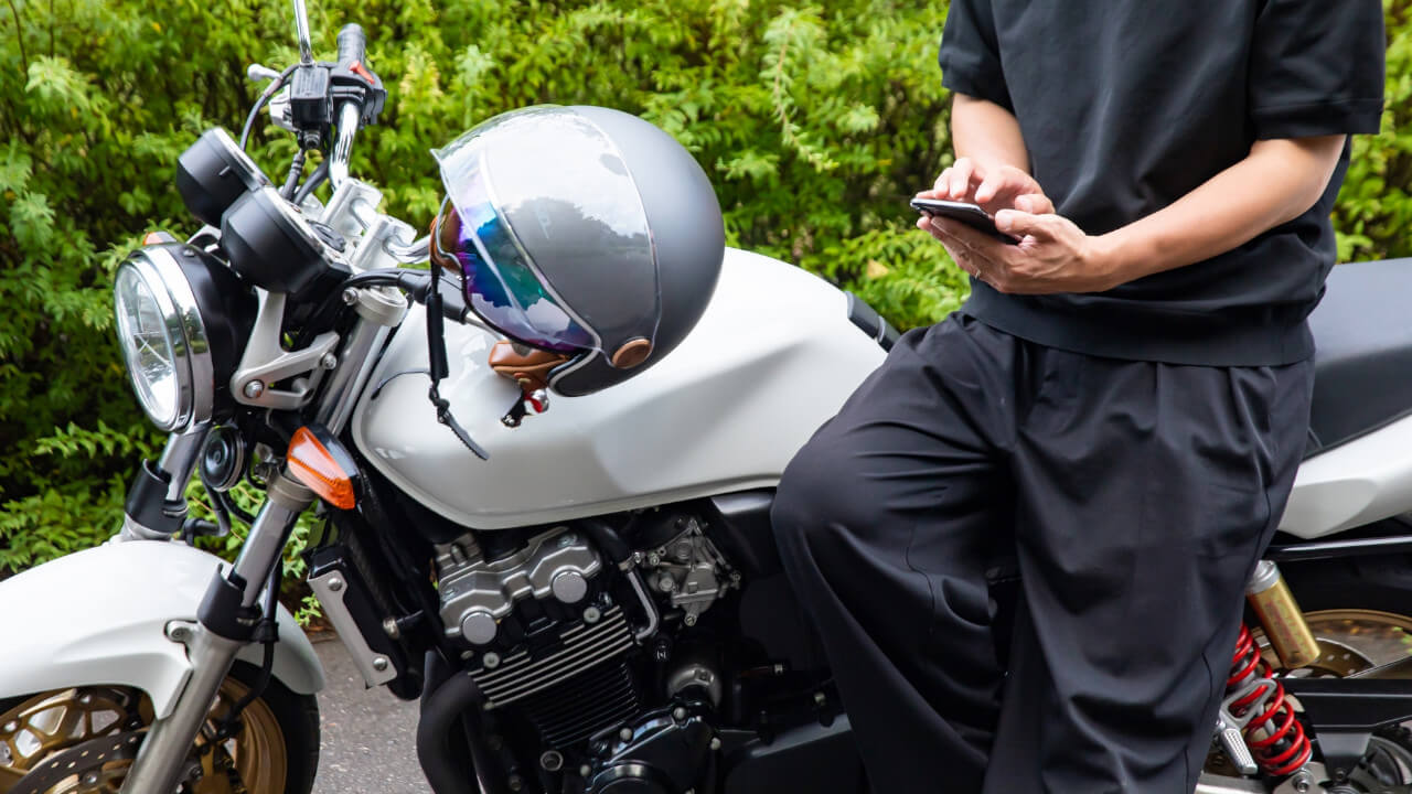 男性ライダーがスマートフォンを操作